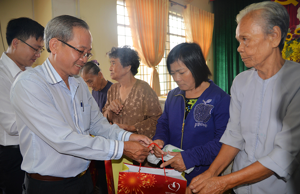 Phó Tổng biên tập Báo An Giang, kiêm Phó trưởng ban Công tác XHTT Báo An Giang Nguyễn Thành Tín trao quà Tết cho các hộ nghèo