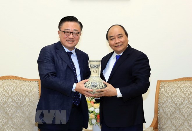 Thủ tướng Nguyễn Xuân Phúc tặng quà lưu niệm cho ông Dongjin Koh, Tổng Giám đốc điều hành Công ty Samsung Điện tử Hàn Quốc. (Ảnh: Thống Nhất/TTXVN)