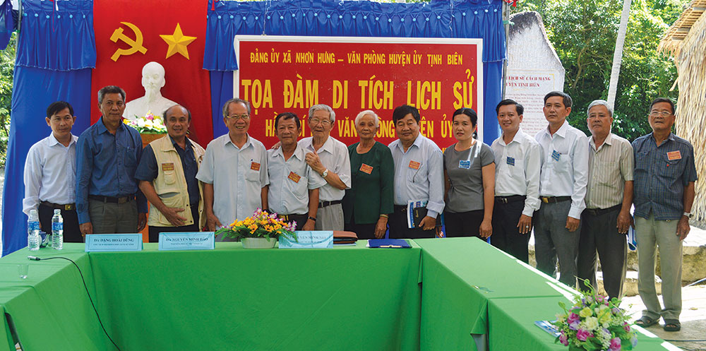 Ông Nguyễn Minh Nhị và Nguyễn Minh Đào (đứng thứ 4 và thứ 6, từ trái sang) trong lần về thăm Di tích lịch sử Hầm bí mật Văn phòng Huyện ủy Tịnh Biên