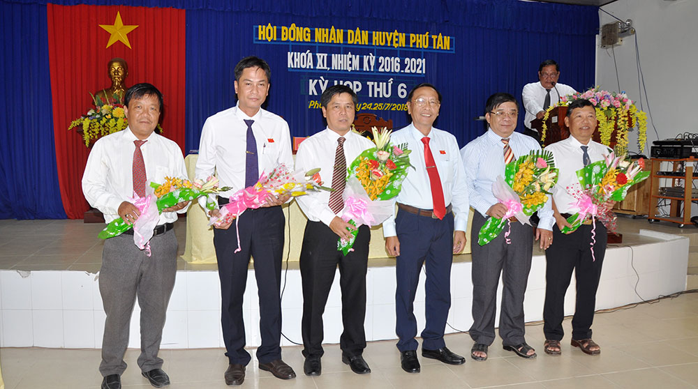 Bí thư Huyện ủy Phú Tân Lâm Phước Trung tặng hoa cho các đại biểu miễn nhiệm thôi giữ chức vụ. Ảnh: MỸ HẠNH