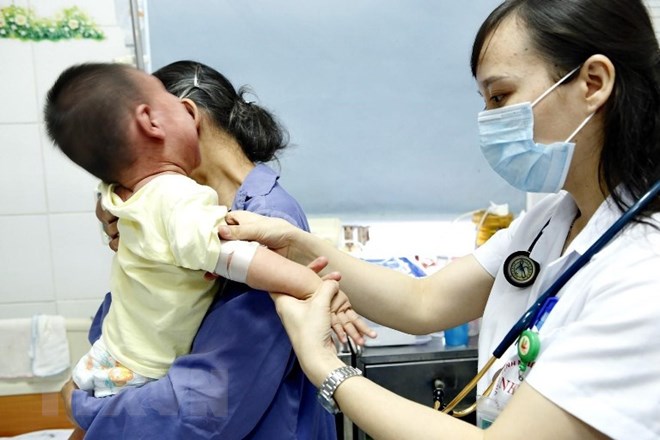 Bác sỹ Bệnh viện bệnh Nhiệt đới Trung ương điều trị trẻ mắc sởi bị viêm phổi rất nặng do không tiêm chủng. (Ảnh: Dương Ngọc/TTXVN)