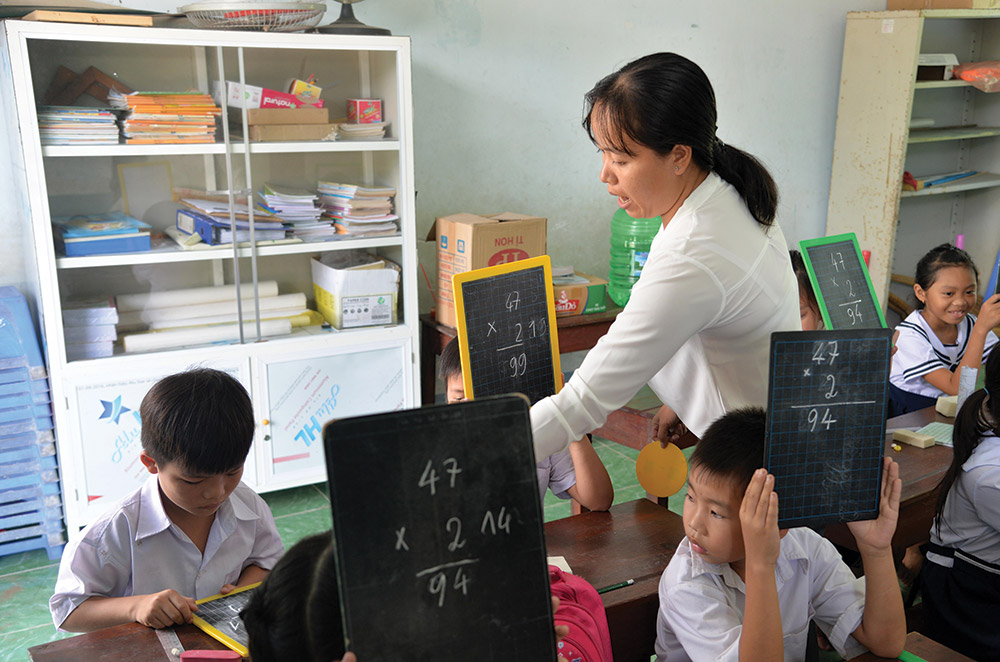 Cô giáo hướng dẫn các em học sinh tính toán