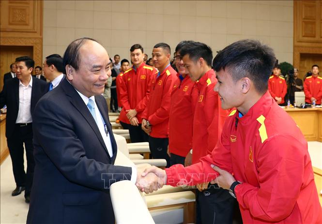 Thủ tướng Nguyễn Xuân Phúc với cầu thủ Quang Hải và các thành viên đội tuyển bóng đá nam. 