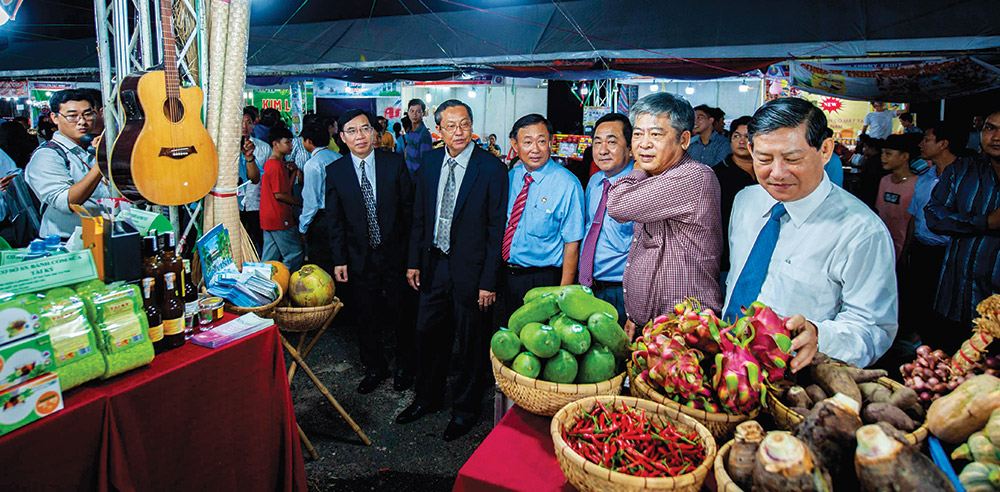Phó Chủ tịch UBND tỉnh An Giang Lê Văn Nưng (thứ 5 từ bên phải) cùng đại biểu tham quan các gian hàng tại hội chợ