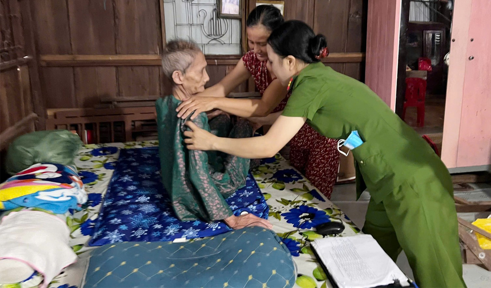 Hỗ trợ, chỉnh lại tư thế cho bà Nguyễn Thị Dần (sinh năm 1936, ngụ khóm Tây Khánh 2) trước khi thực hiện làm căn cước