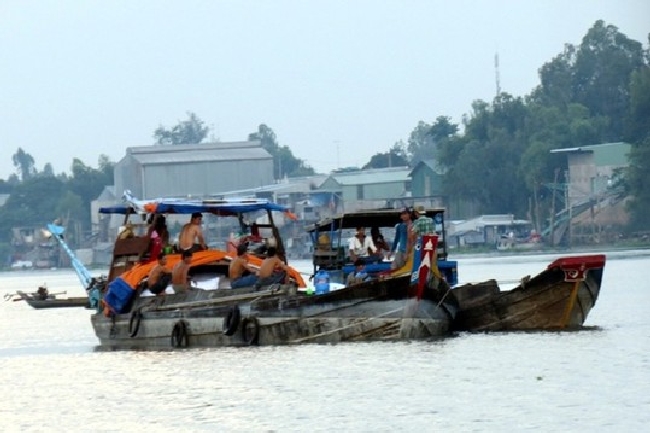 Chiếc ghe chài chở khoảng 100 tấn đường đậu sát bờ sông Hậu phía Campuchia đang sang đường cho các ghe Việt Nam để vào địa phận An Giang.