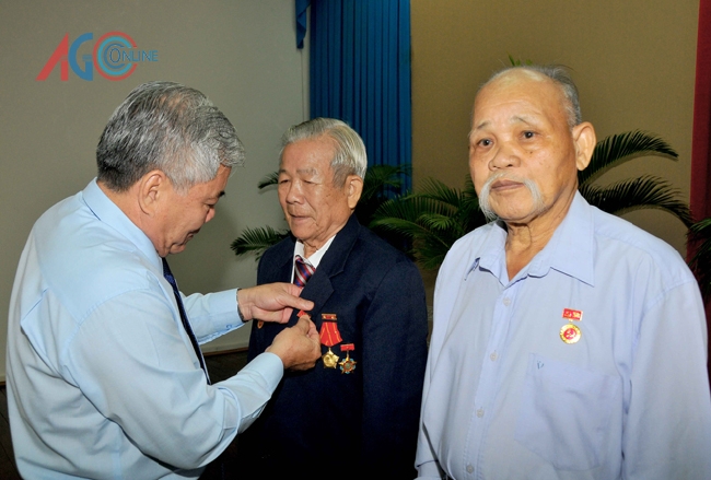 Bí thư Tỉnh ủy Phan Văn Sáu trao Huy hiệu và tặng hoa chúc mừng các đảng viên cao niên tuổi Đảng.