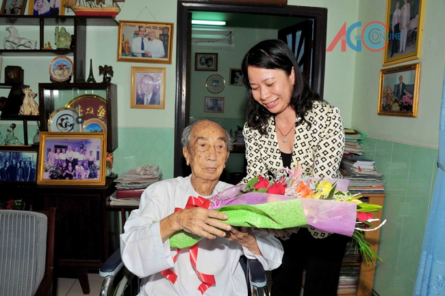 Phó Bí thư Tỉnh ủy Võ Thị Ánh Xuân tặng hoa, chúc sức khỏe cán bộ lão thành Cách mạng, 70 năm tuổi Đảng Nguyễn Khắc Thận.