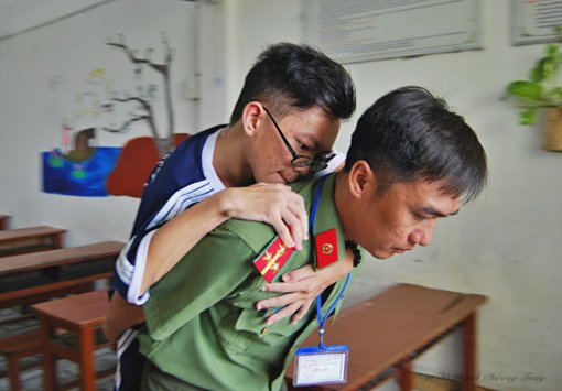 Cảm động hình ảnh chiến sĩ công an cõng thí sinh bị liệt đi thi