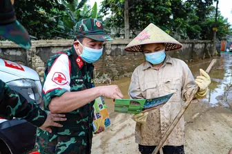 Quân y đến từng nhà, từng lớp học phun khử khuẩn, khám bệnh cho người dân vùng lũ