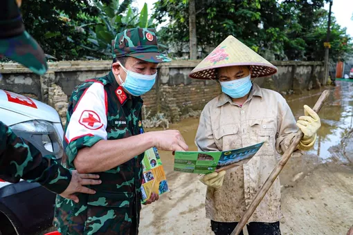 Quân y đến từng nhà, từng lớp học phun khử khuẩn, khám bệnh cho người dân vùng lũ